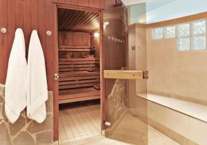 a bathroom with a shower and a glass door at H4 Hotel Hannover Messe in Hannover +37 photos