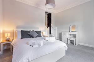 a white bedroom with a large white bed and a desk at Guest Homes - Droitwich Road Dwelling in Worcester