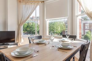 uma sala de jantar com uma mesa com cadeiras e uma grande janela em Guest Homes - Droitwich Road Dwelling em Worcester