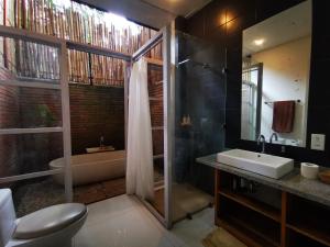 a bathroom with a shower and a sink and a tub at Villa Rimba Ubud in Tegalalang