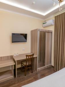 a room with a desk and a television on the wall at Grand Vizir Hotel in Khiva