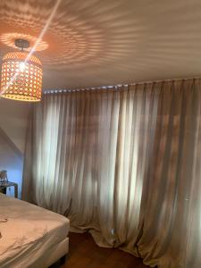 a bedroom with a curtain and a chandelier at Maju in Antwerp