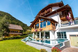 a house in the mountains with a balcony at Berghotel Miramonti in Tesero