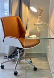 escritorio de cristal con silla y lámpara en Ground Floor Apartment Midrand en Midrand