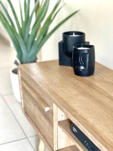 - une table en bois avec deux tasses de café noir dans l'établissement Ground Floor Apartment Midrand, à Midrand