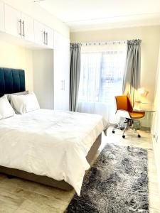 - une chambre avec un lit, un bureau et une chaise dans l'établissement Ground Floor Apartment Midrand, à Midrand
