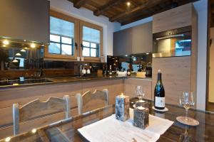 uma cozinha com uma mesa e uma garrafa de vinho em Chalet Matterland em Zermatt