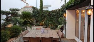 a wooden table and chairs in a garden at La Martinoise Patio in Saint-Martin-de-Ré