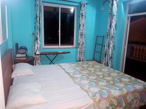 a blue bedroom with a bed and a window at River side apartment in Cavelossim +15 photos