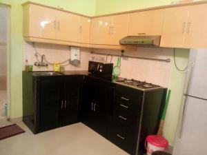a kitchen with black cabinets and a stove top oven at River side apartment in Cavelossim