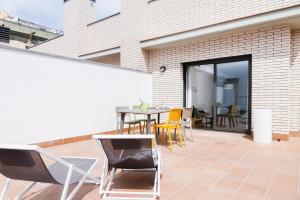 a patio with chairs and a table on a balcony at Feelathome Plaza Apartments in Barcelona