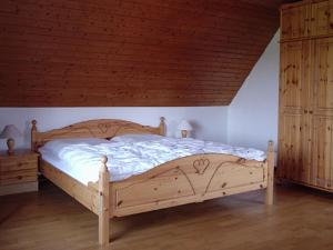 een groot houten bed in een slaapkamer met 2 kasten bij Ferienhaus Küste in Otterndorf