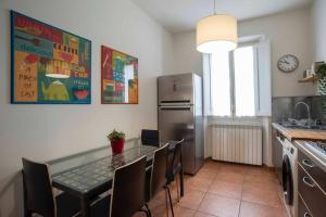 a kitchen with a table with chairs and a refrigerator at Bronzino Flexyrent Renewed - AC - WiFi in Florence