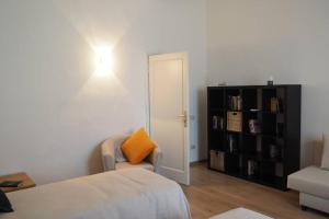 a bedroom with a bed and a chair with an orange pillow at Bronzino Flexyrent Renewed - AC - WiFi in Florence