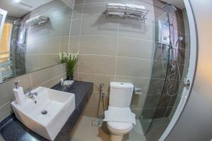 新山的住宿－Hotel SIN JO，一间带水槽、卫生间和镜子的浴室