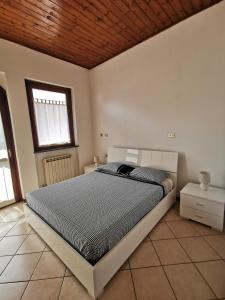 1 dormitorio con 1 cama grande y techo de madera en FRANK'S HOME, en Lonate Pozzolo