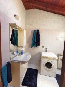 bagno con lavatrice e lavandino di FRANK'S HOME a Lonate Pozzolo