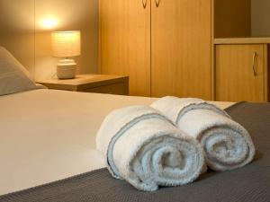 a group of towels are stacked on a bed at Lake Tyrrell Accommodation LTA in Sea Lake