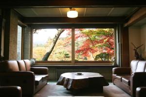 uma sala de estar com uma grande janela e uma mesa de centro em Nikko Kanaya Hotel em Nikko