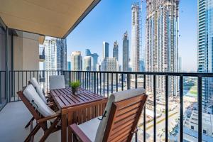 d'un balcon avec une table et des chaises en bois et une vue sur la ville. dans l'établissement High-End Chic Apartment, Close to Burj Khalifa, à Dubaï