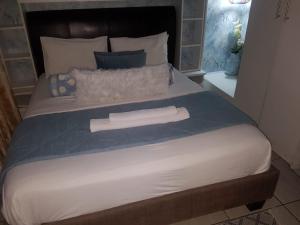 a large bed with two white towels on it at Corgi Guest House in Johannesburg
