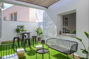 a patio with green grass and a table and chairs at La Plaza-Colón in Villafranca de los Barros