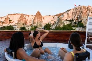 two women in bathing suits are sitting in a pool at Hostel Terra Vista in Goreme