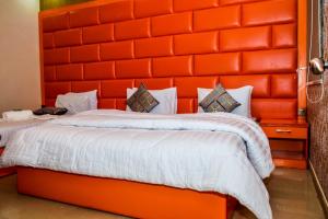 two beds in a room with an orange headboard at Clifton Rezidor in Karachi