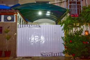 a white gate with a green umbrella above it at Clifton Rezidor in Karachi