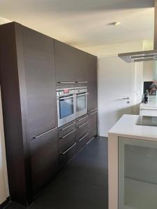 uma cozinha com armários de aço inoxidável e um micro-ondas em Luxury House with big garden and mountain view ( 3 bedrooms) em Haag