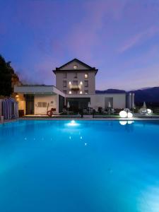 a large swimming pool in front of a house at Bellavista Relax Hotel in Levico Terme