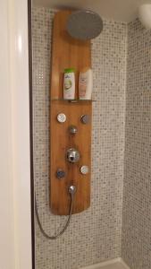 y baño con ducha y estante de madera. en Chambre Avec Jardin Pierre Curie en Bry-sur-Marne
