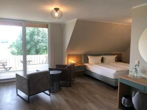 ein Hotelzimmer mit einem Bett und einem großen Fenster in der Unterkunft Hotel Alte Fischerkate in Mödlich