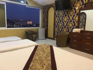 ein Hotelzimmer mit 2 Betten und einem Fenster in der Unterkunft Hashimi Hotel in Jerusalem