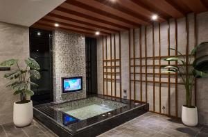 łazienka z wanną z telewizorem w obiekcie Motel Lin w mieście Taizhong