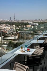 un tavolo e sedie su un balcone con vista sulla città di Melia Paris La Defense a Courbevoie