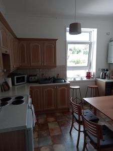 cocina con armarios de madera, mesa y ventana en Apartment in the heart of Callander en Callander