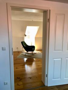 uma cadeira preta sentada num quarto com uma porta em Studio in der Celler Altstadt em Celle