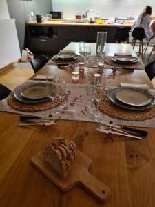 una mesa con platos y vasos y un pastel. en Gite La Petite Beurrerie des Ardennes, en Celles