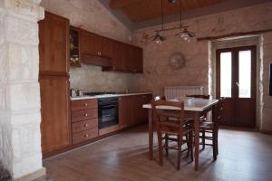 a kitchen with wooden cabinets and a table with chairs at La casa di Zio Donato in Roccamorice