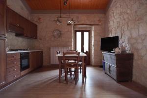 uma cozinha com uma mesa e cadeiras e uma televisão em La casa di Zio Donato em Roccamorice
