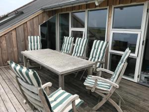 a wooden table and four chairs on a deck at Skippergaarden in Præstø