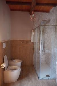 a bathroom with a toilet and a glass shower at La casa di Zio Donato in Roccamorice