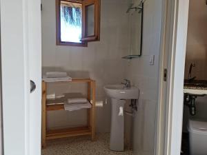 a white bathroom with a sink and a mirror at Chozos Las Flores de la Dehesa in Calzadilla
