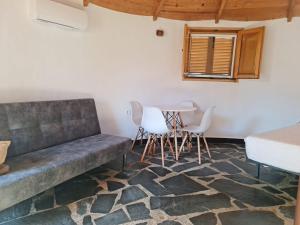 a living room with a couch and a table at Chozos Las Flores de la Dehesa in Calzadilla