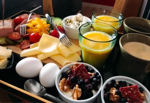 a tray of food with eggs cheese and fruit and drinks at Villa Lindell in Höganäs