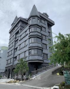 un gran edificio gris con techo puntiagudo en Gaodiyuan Tea B&B 高帝園茶業民宿 en Meishan