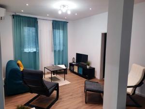 a living room with a couch and chairs and a television at Apartment Neretva in Čapljina