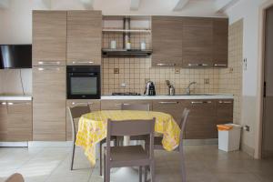 a kitchen with a table with a yellow table cloth on it at B&B Domus del Sole in Siponto