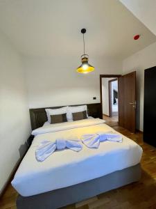 ein Schlafzimmer mit einem großen weißen Bett mit Bögen darauf in der Unterkunft Mia's Favorite Hotel in Mavrovo-Nationalpark